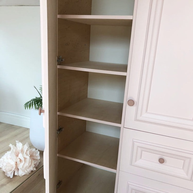 Wnętrze szafy z półkami i drążkiem na ubrania – widok z otwartymi drzwiami