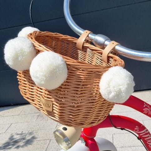 naturalny wiklinowy koszyk na rower dla dzieci Dumpy w paski z pomponami