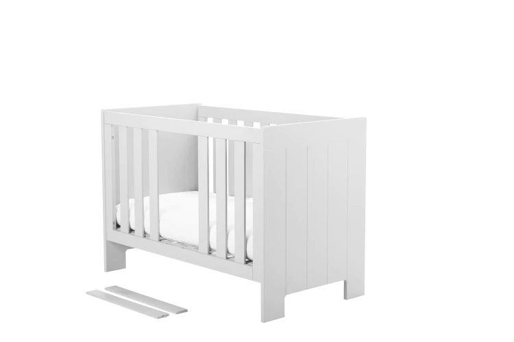Białe łóżeczko niemowlęce Calmo 60x120 cm z regulowanym dnem i wyjmowanymi szczebelkami, możliwość montażu szuflady, bezpieczne dla niemowląt
