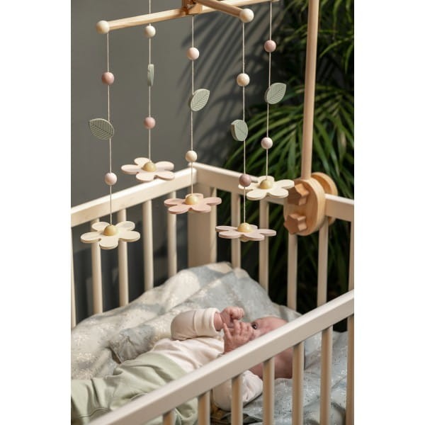 Drewniane mobile kwiaty w pastelowych kolorach zawieszone nad łóżeczkiem