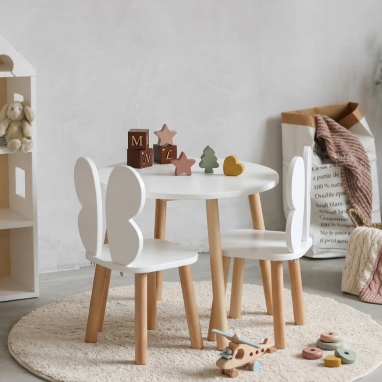 drewniany stolik dziecięcy z krzesełkami motylkami w stylu skandynawskim w jasnym pokoju dziecka