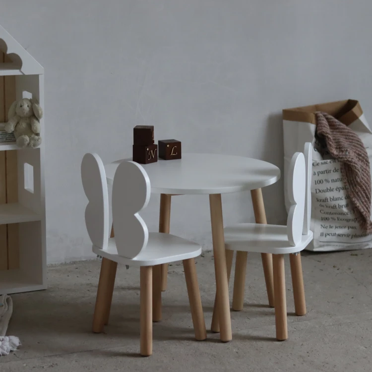 drewniany stolik dziecięcy z krzesełkami motylkami w stylu skandynawskim w jasnym pokoju dziecka