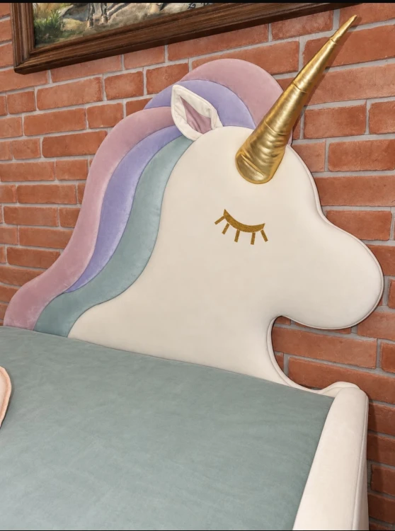 Tapicerowane łóżko dziecięce UNICORN DAPPI Kids z zagłówkiem w kształcie jednorożca i pojemnikiem na pościel.